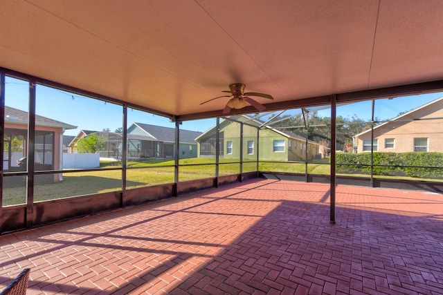 unfurnished sunroom with ceiling fan