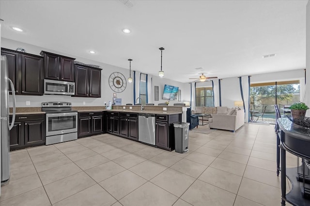 kitchen with ceiling fan, kitchen peninsula, stainless steel appliances, and decorative light fixtures