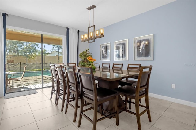 tiled dining room featuring an inviting chandelier