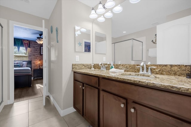 bathroom featuring tile patterned flooring, vanity, ceiling fan with notable chandelier, and walk in shower