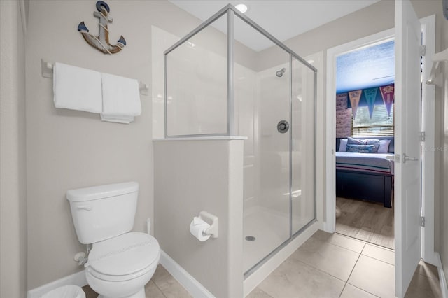 bathroom with tile patterned floors, toilet, and an enclosed shower