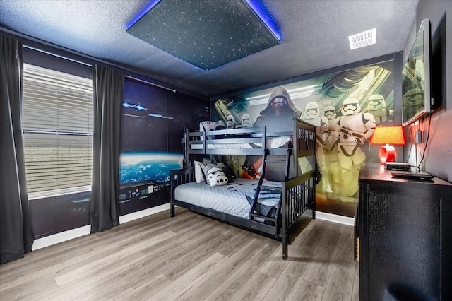 bedroom featuring wood-type flooring and a textured ceiling