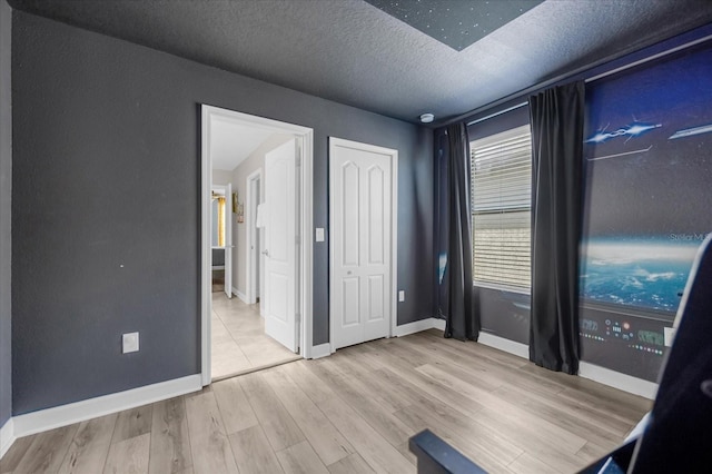 unfurnished bedroom featuring a textured ceiling and light hardwood / wood-style flooring