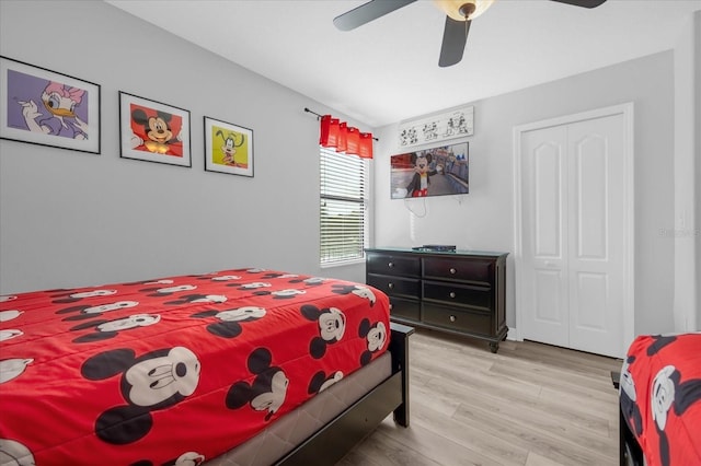 bedroom with ceiling fan, light hardwood / wood-style floors, and a closet