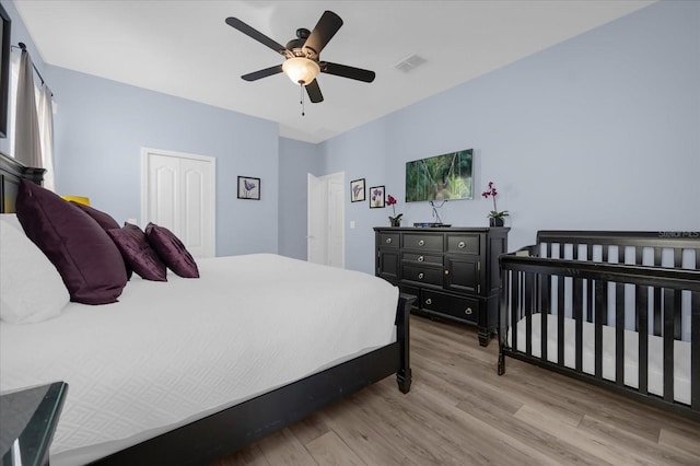 bedroom featuring ceiling fan, a closet, and light hardwood / wood-style floors