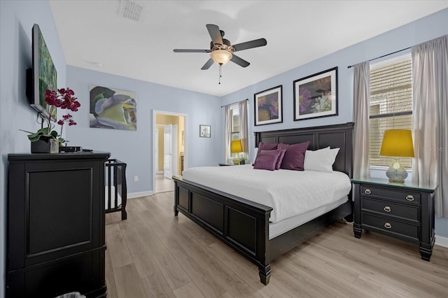 bedroom with ensuite bath, ceiling fan, and light hardwood / wood-style floors