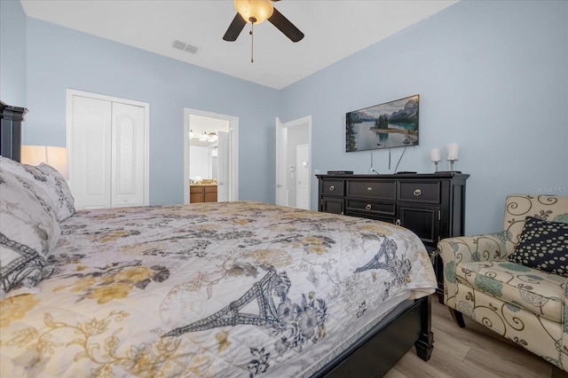 bedroom featuring connected bathroom, light wood-type flooring, a closet, and ceiling fan