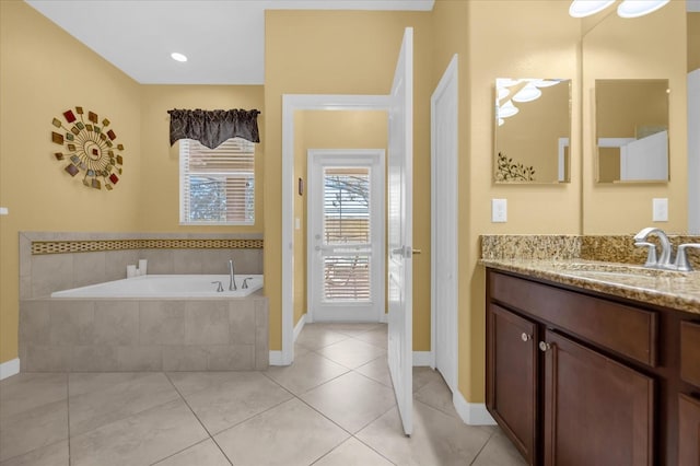 bathroom featuring tile patterned flooring, vanity, and tiled bath