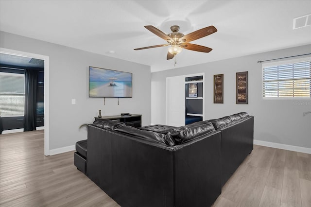 living room featuring light hardwood / wood-style flooring and ceiling fan