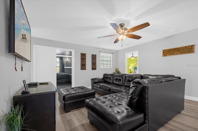 living room with light hardwood / wood-style floors and ceiling fan