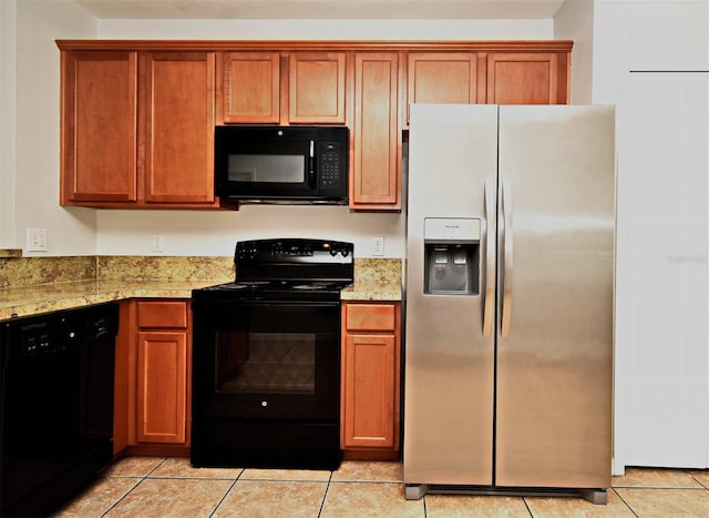 kitchen with light tile patterned floors, light stone counters, and black appliances