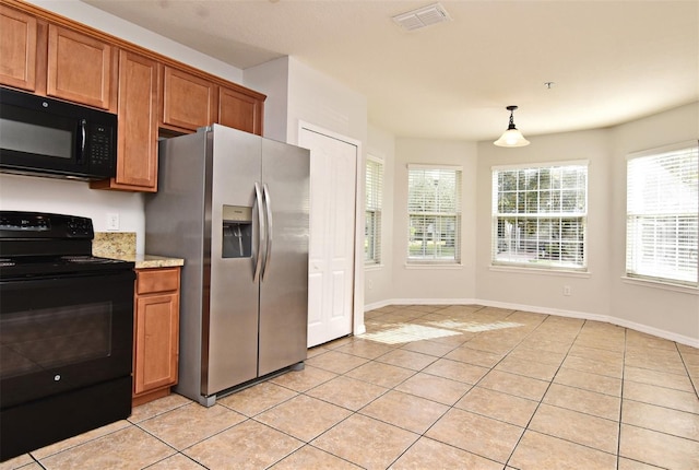 kitchen with pendant lighting, light tile patterned floors, and black appliances