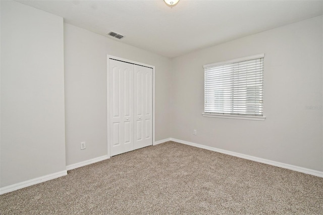 unfurnished bedroom featuring carpet flooring and a closet