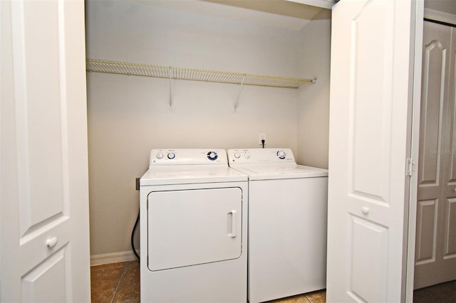 washroom with washing machine and dryer and dark tile patterned floors