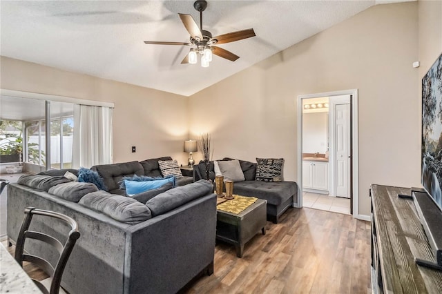 living room featuring hardwood / wood-style floors, ceiling fan, and vaulted ceiling