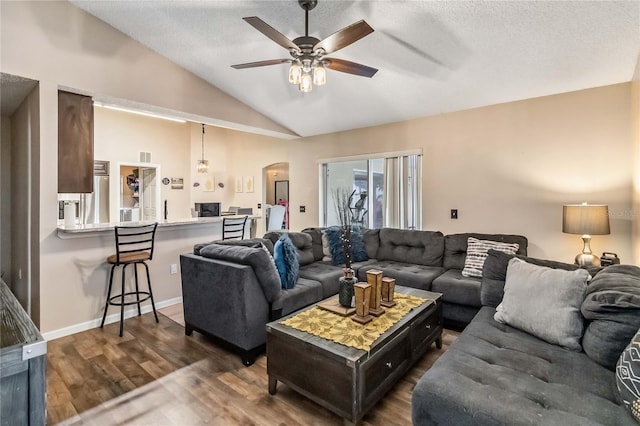 living room featuring a textured ceiling, ceiling fan, dark hardwood / wood-style flooring, and lofted ceiling