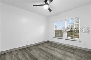 unfurnished room with ceiling fan and dark hardwood / wood-style flooring