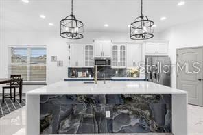 kitchen with pendant lighting, stainless steel appliances, and white cabinetry