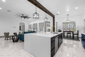 kitchen with ceiling fan, sink, stainless steel dishwasher, an island with sink, and decorative light fixtures