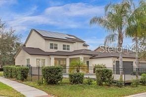 view of front of house with a front yard and solar panels