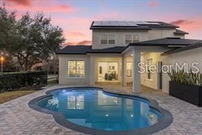 pool at dusk with a patio