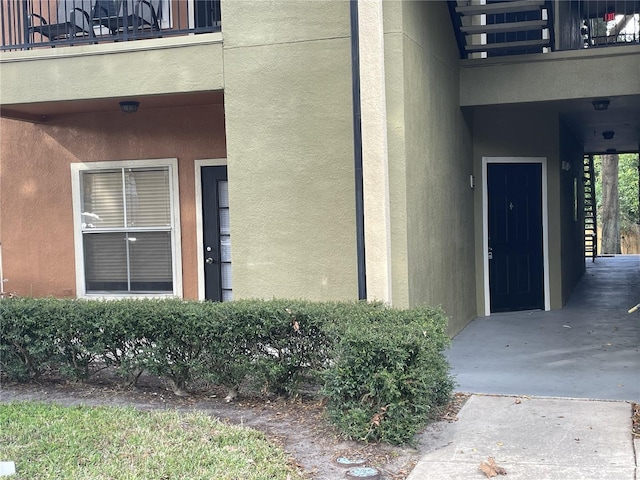 view of exterior entry with a balcony