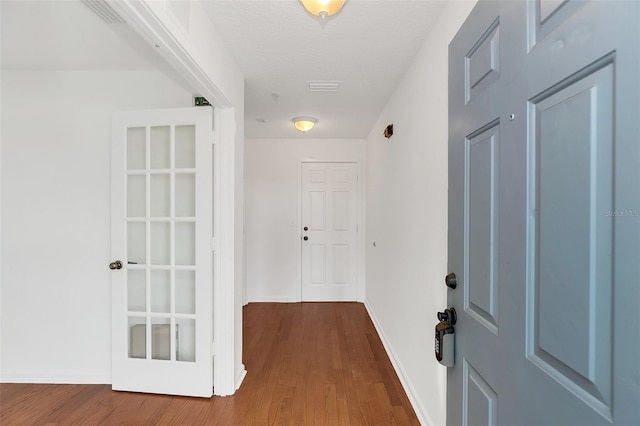 corridor featuring hardwood / wood-style floors and a textured ceiling