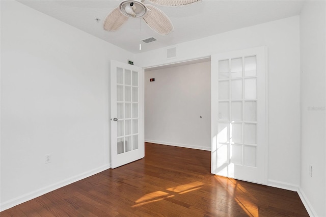 unfurnished room with ceiling fan, french doors, and dark wood-type flooring