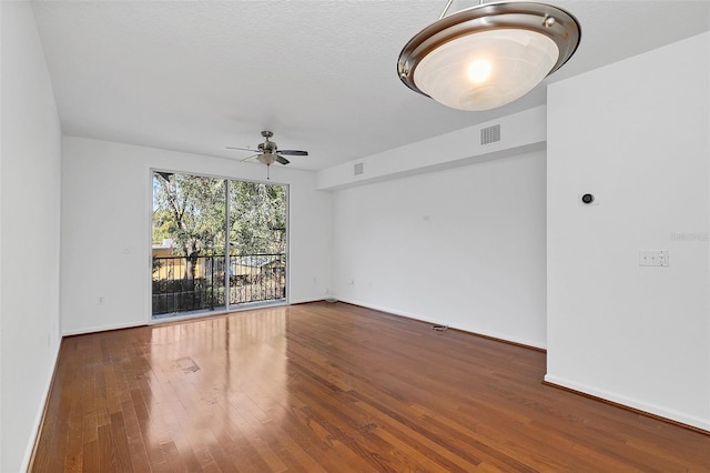 spare room with a textured ceiling, hardwood / wood-style flooring, and ceiling fan