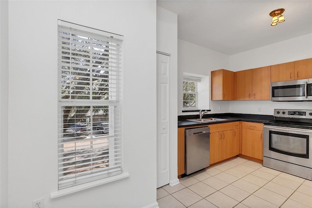 kitchen with light tile patterned flooring, appliances with stainless steel finishes, and sink