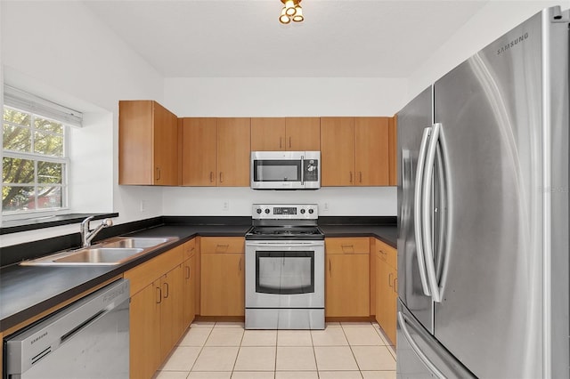 kitchen with sink, light tile patterned flooring, and appliances with stainless steel finishes