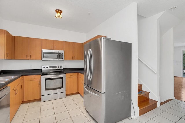 kitchen featuring a textured ceiling, light wood-type flooring, and stainless steel appliances