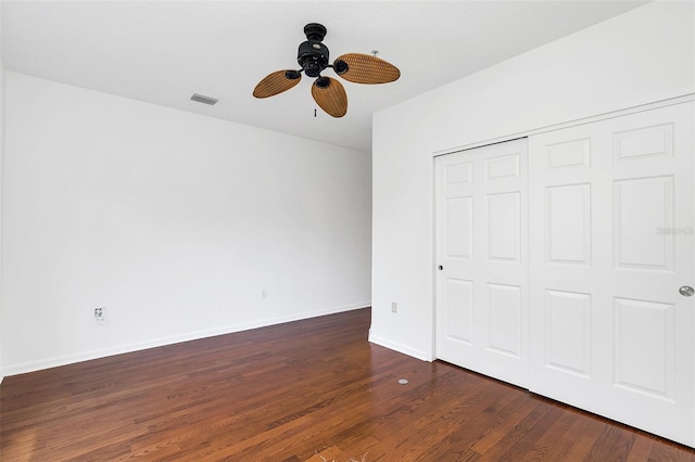 unfurnished bedroom featuring a closet, dark hardwood / wood-style floors, and ceiling fan