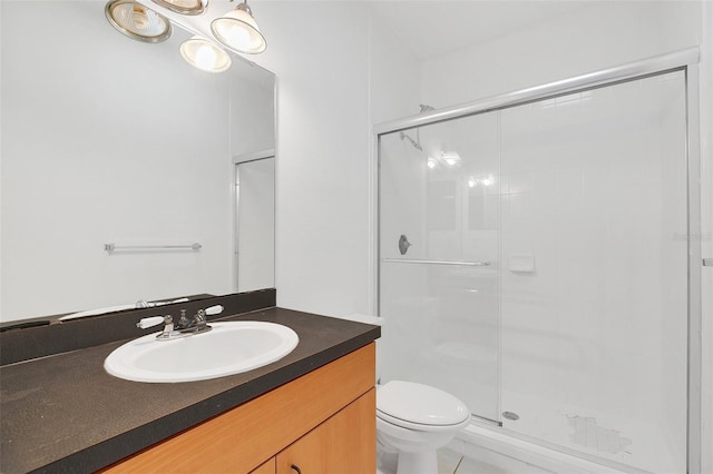 bathroom featuring tile patterned flooring, vanity, an enclosed shower, and toilet