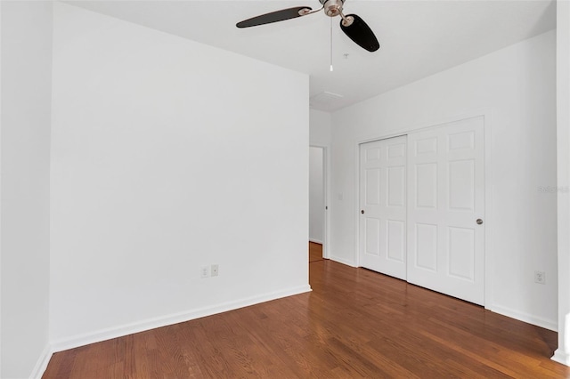 unfurnished bedroom with ceiling fan, dark hardwood / wood-style flooring, and a closet