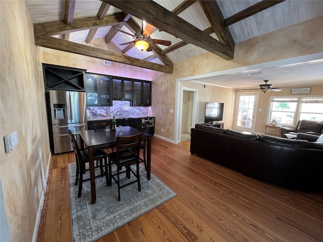 dining area with hardwood / wood-style flooring, ceiling fan, and beamed ceiling