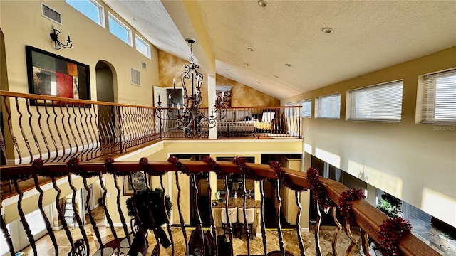 stairs with high vaulted ceiling and a textured ceiling