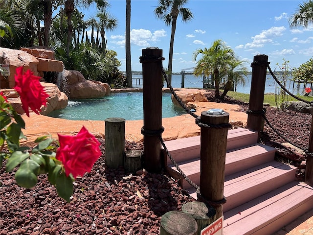 view of pool with pool water feature and a water view