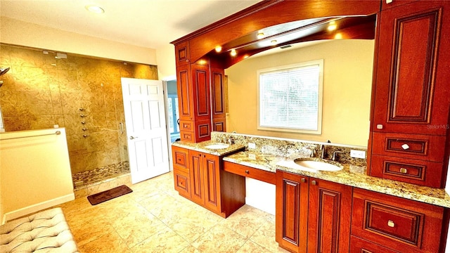 bathroom with a tile shower and vanity