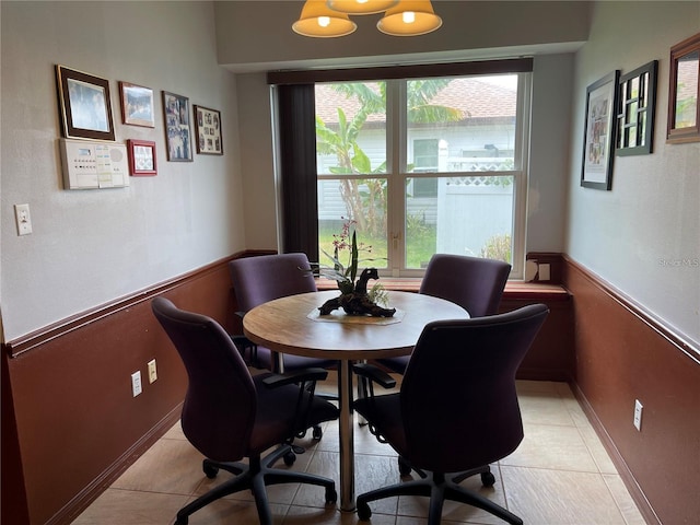 dining room featuring light tile patterned flooring and wainscoting