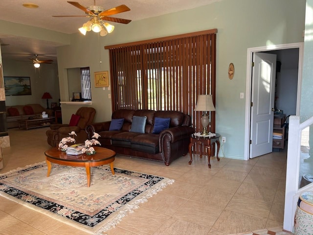 living area featuring baseboards and ceiling fan