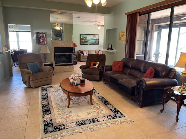 living room with light tile patterned flooring, a ceiling fan, and a tile fireplace