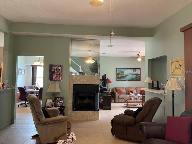 living area featuring tile patterned floors, a fireplace, and ceiling fan