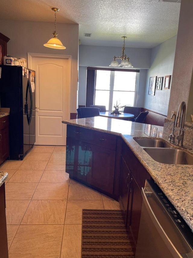 kitchen featuring visible vents, pendant lighting, stainless steel dishwasher, black fridge with ice dispenser, and a sink