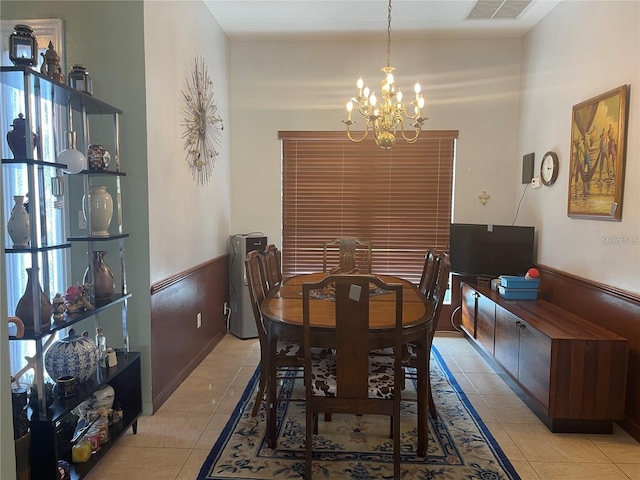 dining area with light tile patterned floors, visible vents, a chandelier, and wainscoting