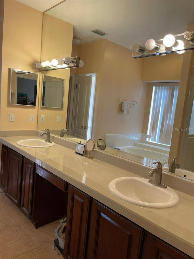 bathroom featuring a sink, visible vents, double vanity, and tile patterned flooring