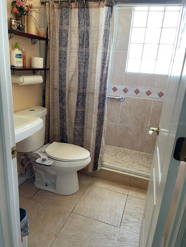 bathroom featuring a tile shower, tile patterned flooring, and toilet