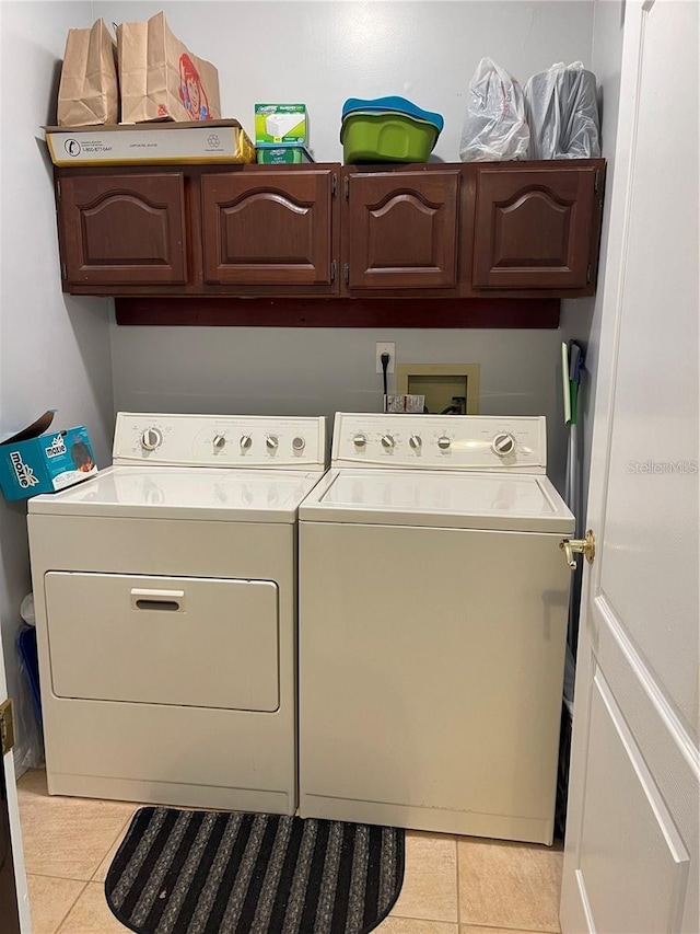 laundry area featuring cabinet space, separate washer and dryer, and light tile patterned flooring