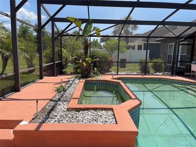 view of pool with glass enclosure, a patio, and a pool with connected hot tub