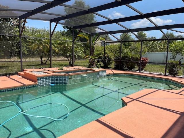 pool with glass enclosure, an in ground hot tub, and a patio